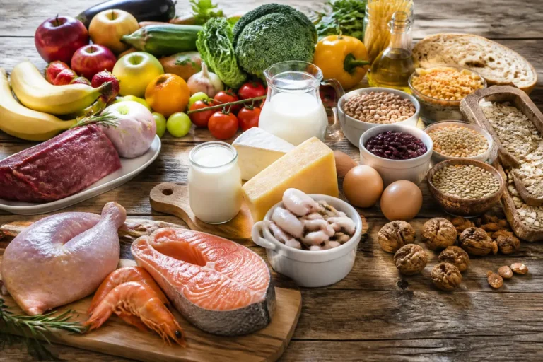 Assortiment varié illustrant les 7 groupes d'aliments avec fruits, légumes, viandes et céréales