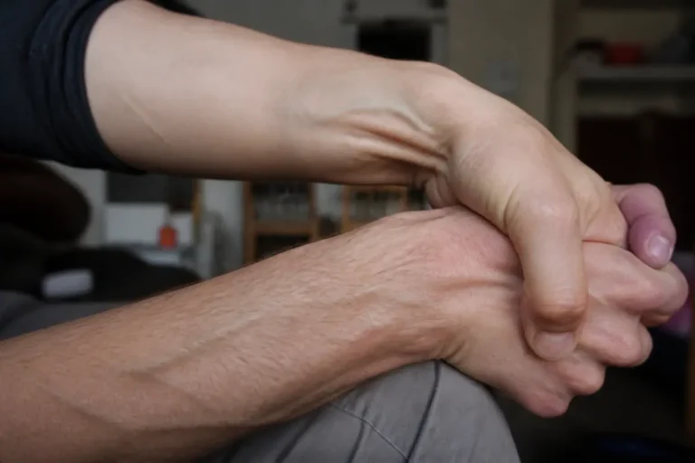 Main se tordant avec poignet qui craque, en gros plan, lumière ambiante